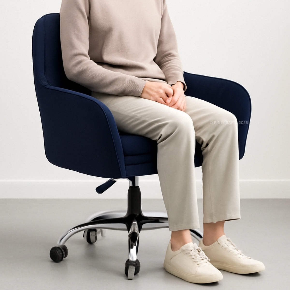 Person sitting on a navy office chair in a minimalistic setting