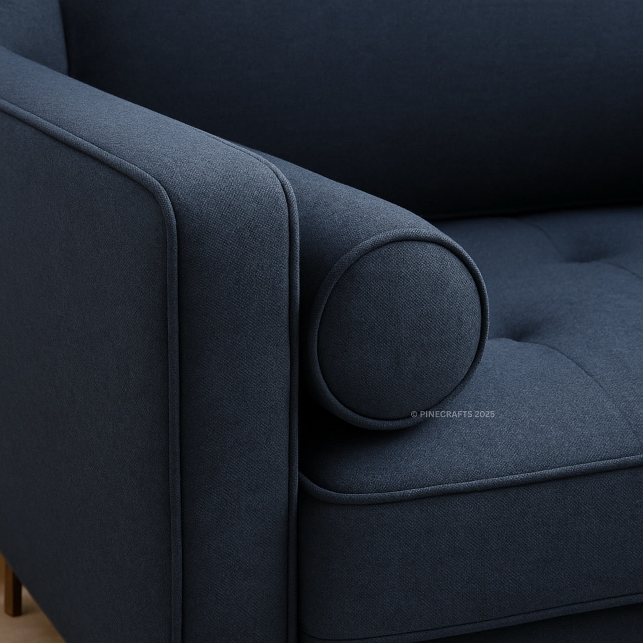 Close-up of a dark blue upholstered chair with tufted details.