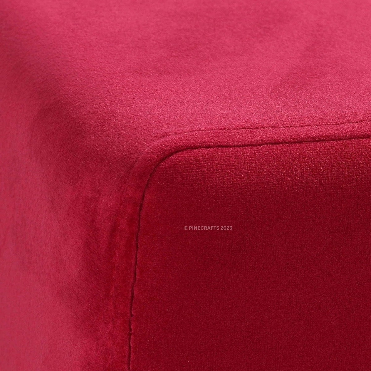 Close-up of a red fabric surface with a brand logo in the corner.