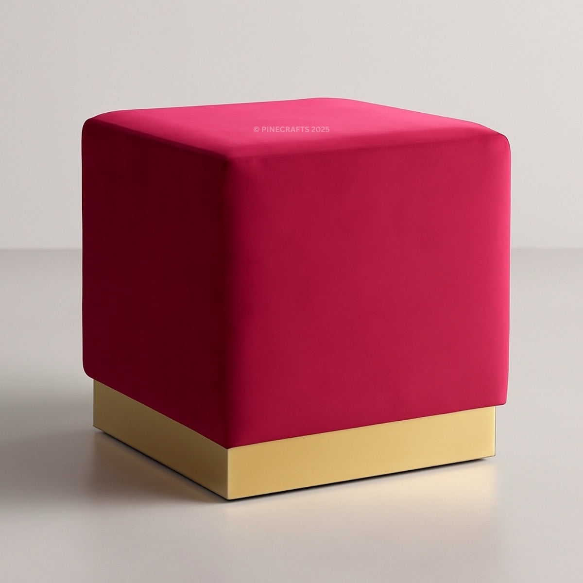 Red cube-shaped ottoman with a gold base on a light gray background