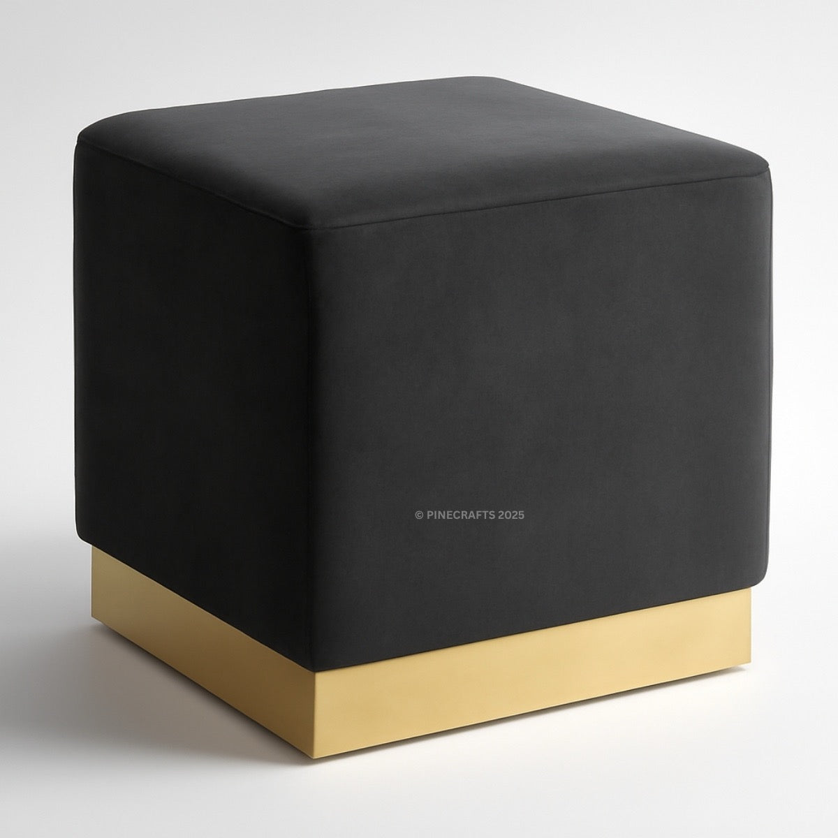 Black cube-shaped ottoman with a gold base on a white background