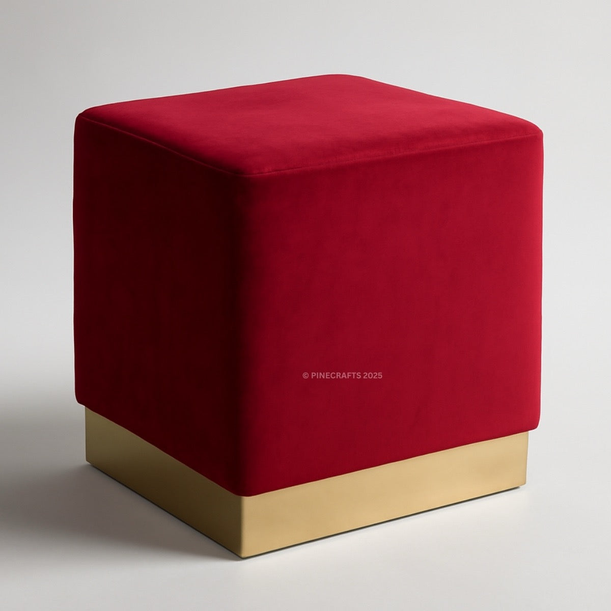 Red cube-shaped ottoman with a gold base on a light gray background