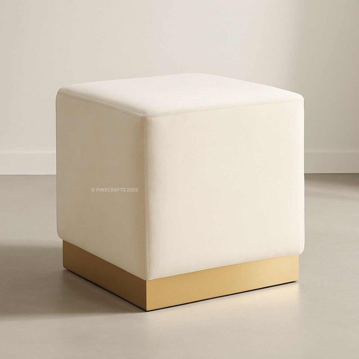 White cube-shaped ottoman with gold base on a neutral background