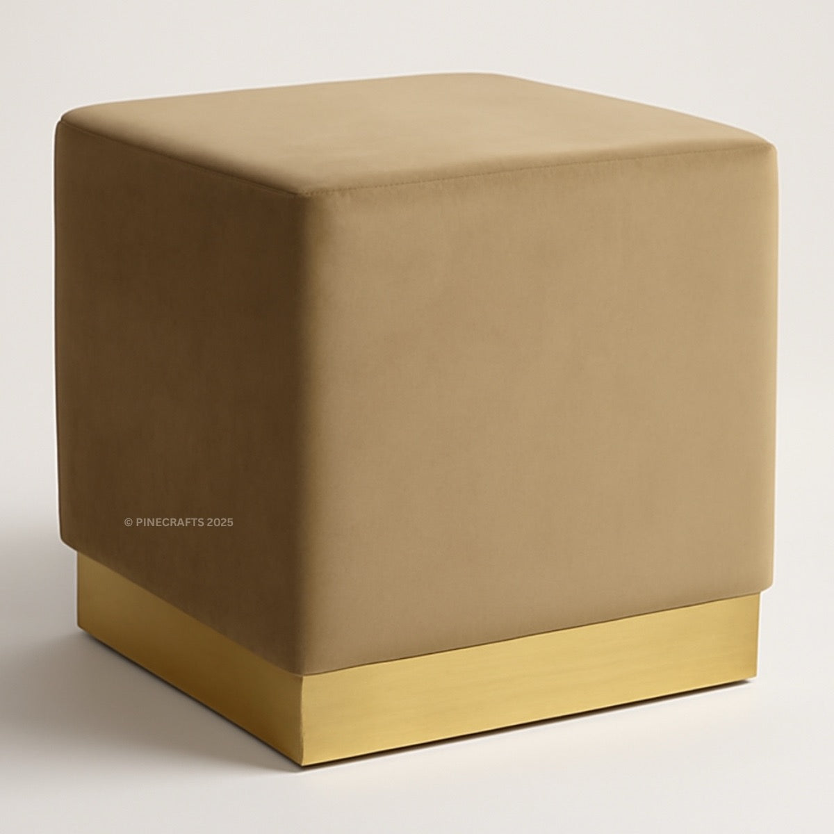 Beige cube-shaped ottoman with a gold base on a white background