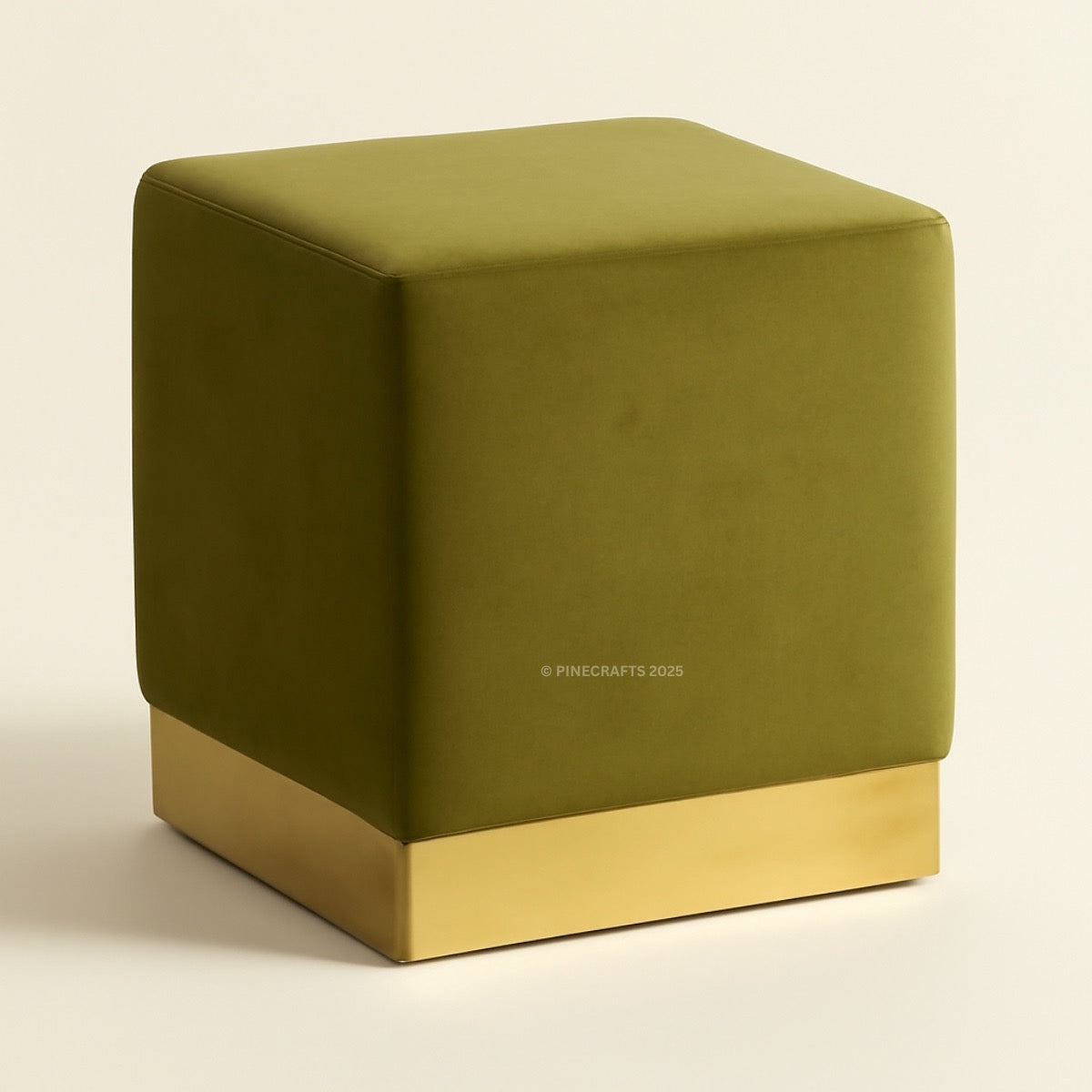 Green cube-shaped ottoman with a gold base on a beige background