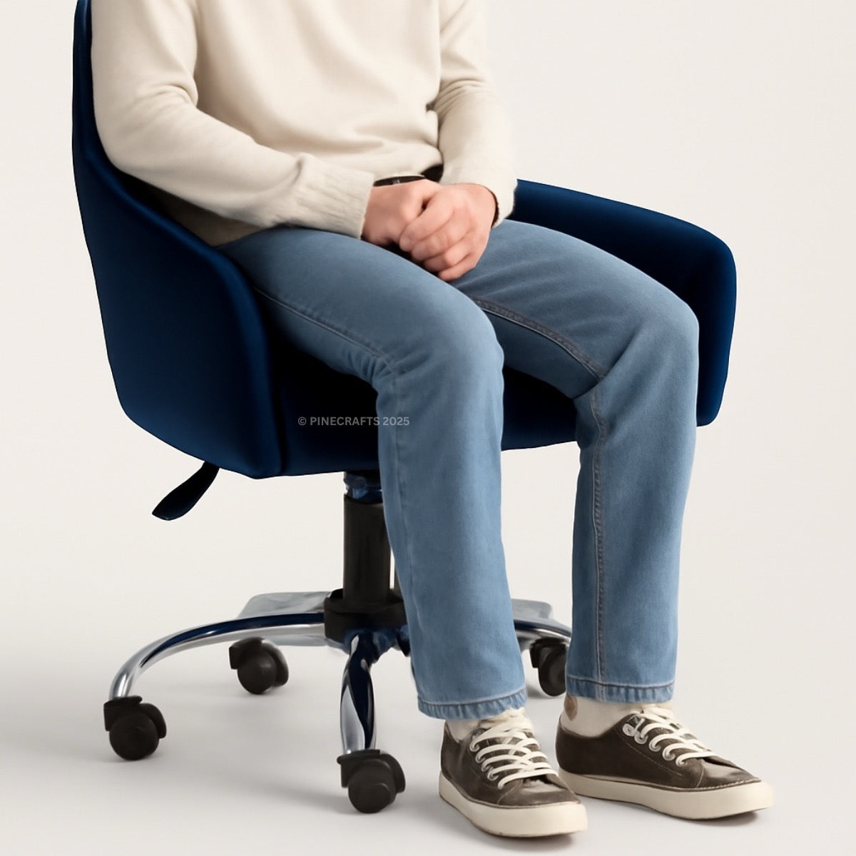Person sitting on a blue office chair wearing jeans and a white sweater.