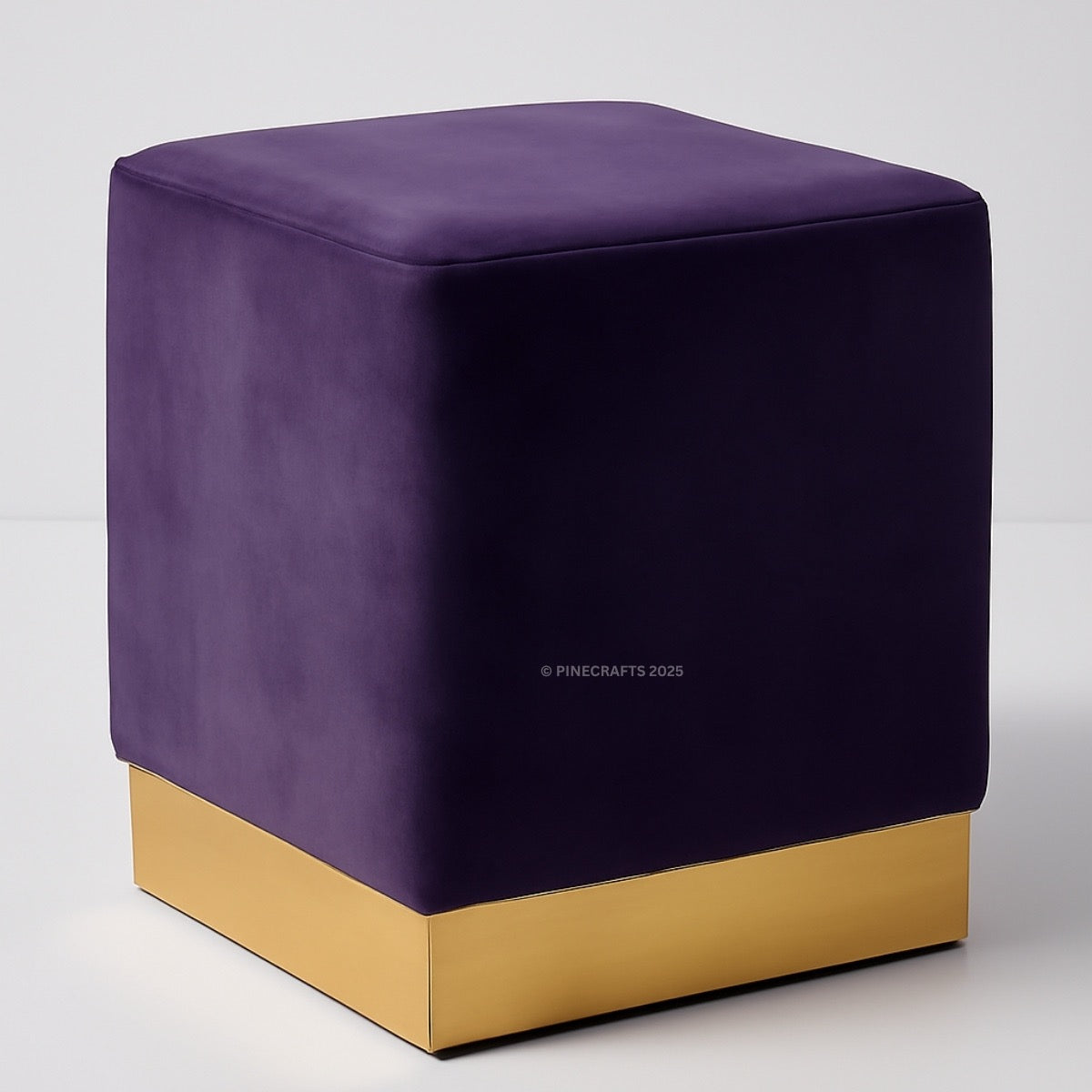 Purple cube-shaped ottoman with gold base on a white background
