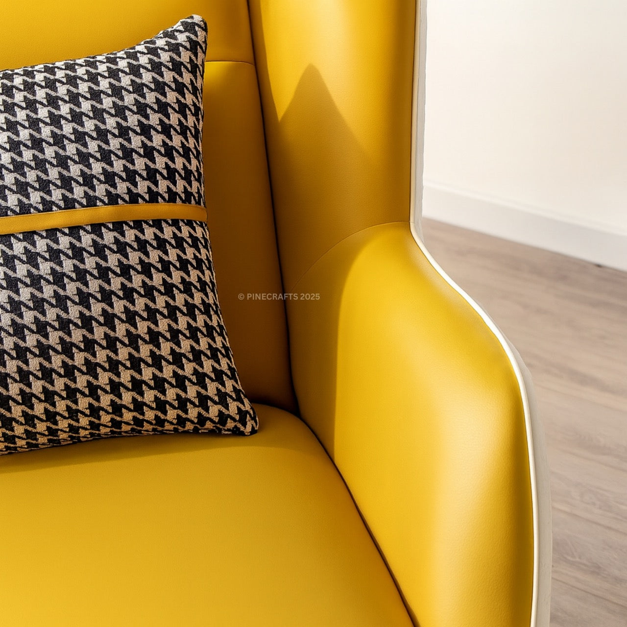 Yellow sofa with a houndstooth pattern pillow on a light wood floor.