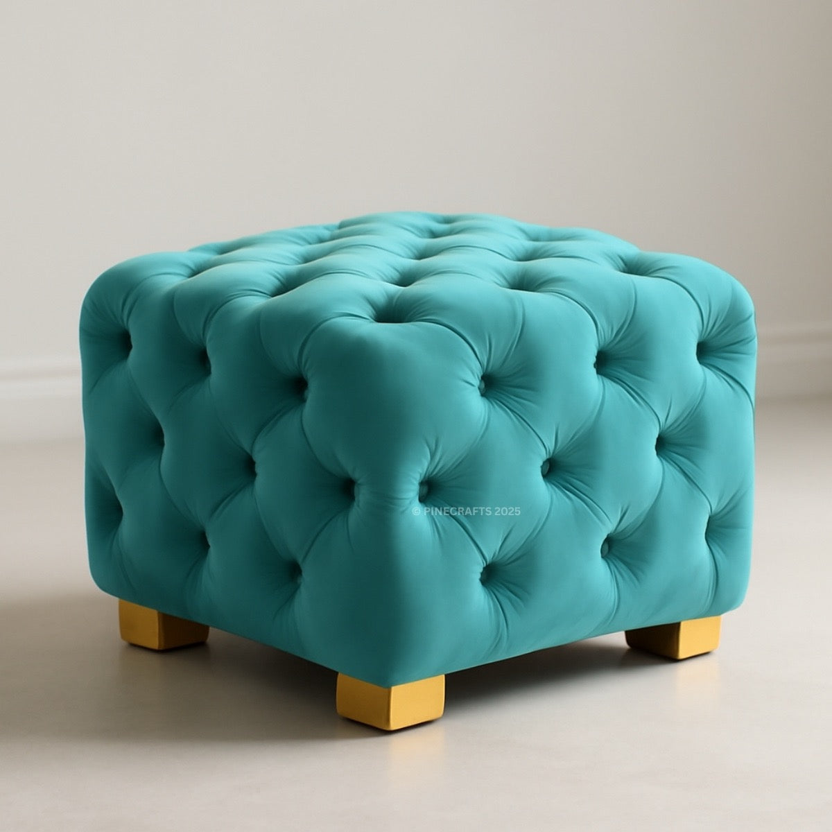 Turquoise tufted ottoman with gold legs on a neutral background