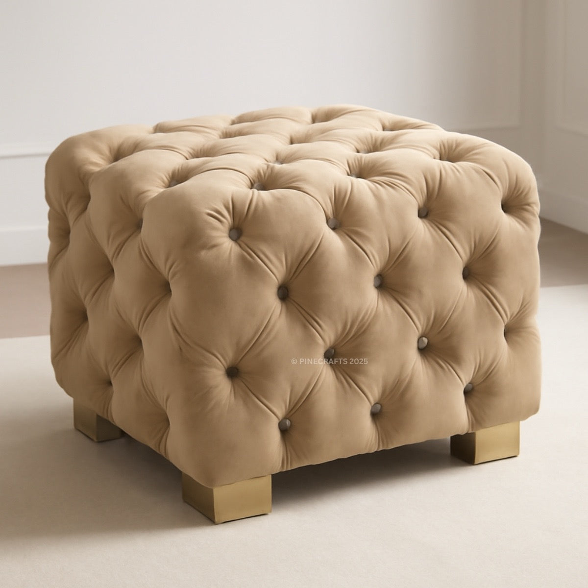 Beige tufted ottoman with gold legs on a neutral background