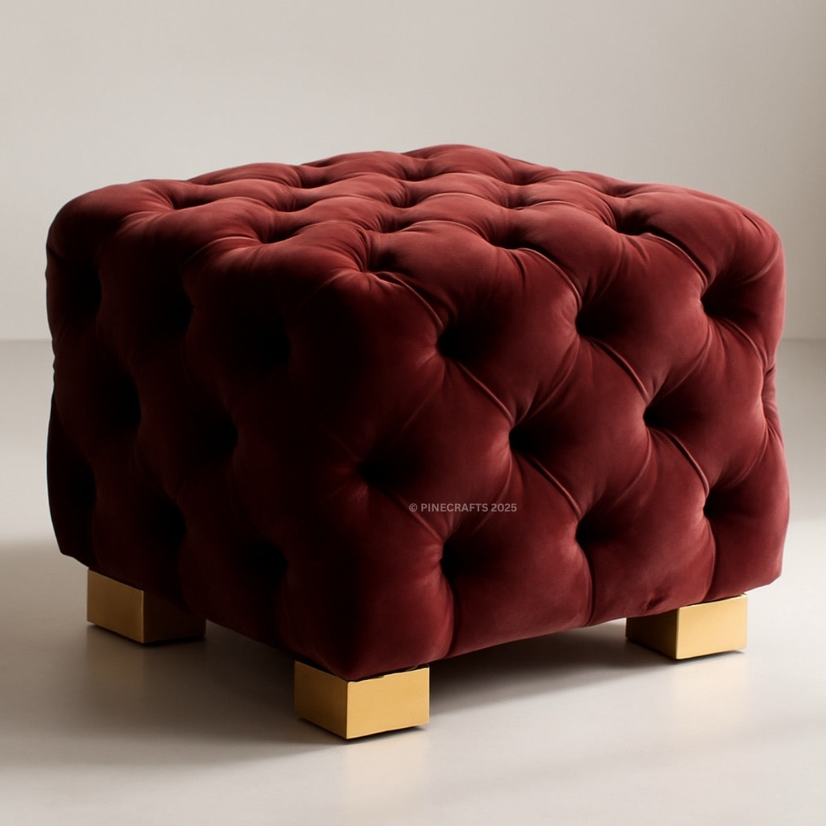 Red tufted ottoman with gold legs on a neutral background