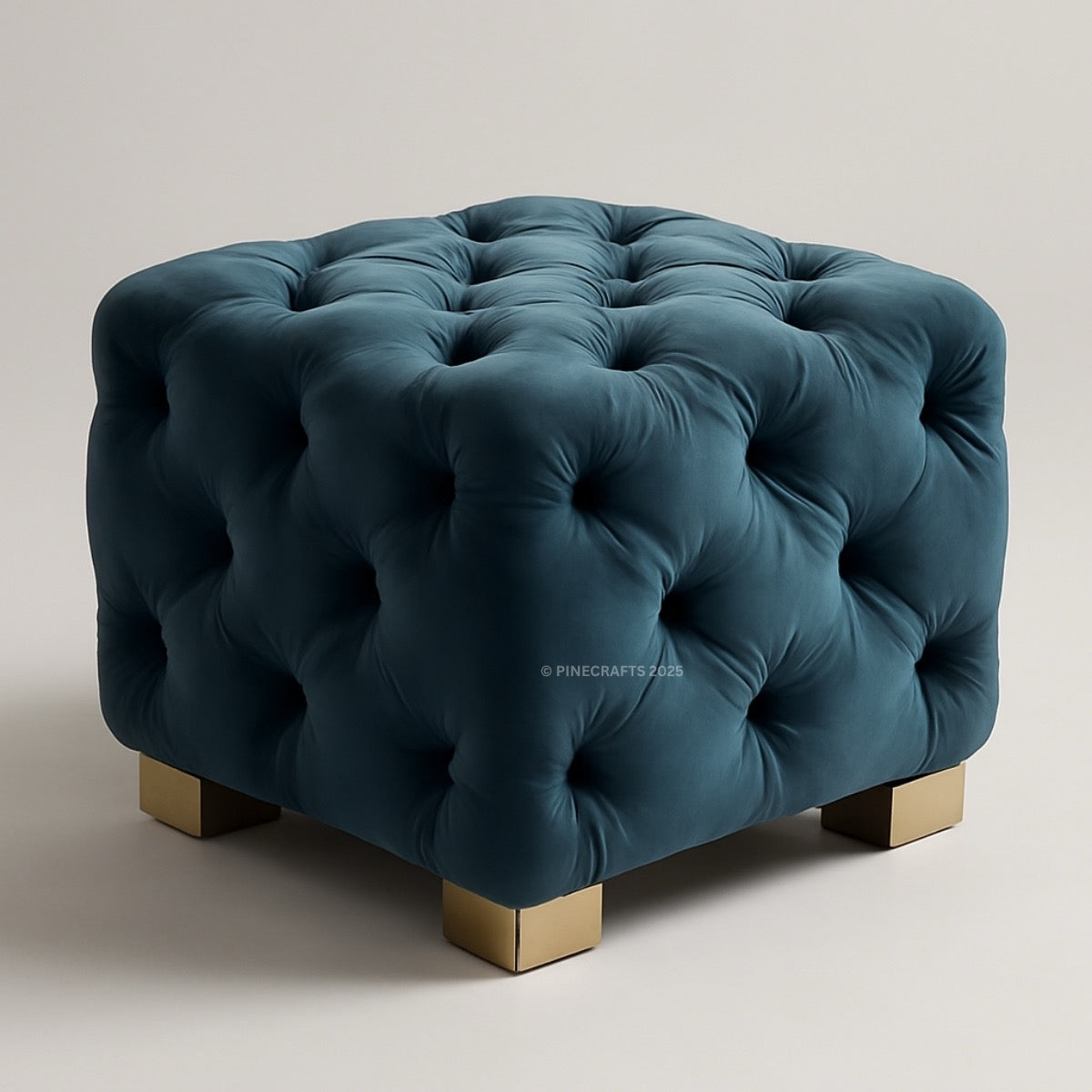 Blue tufted ottoman with gold legs on a light gray background