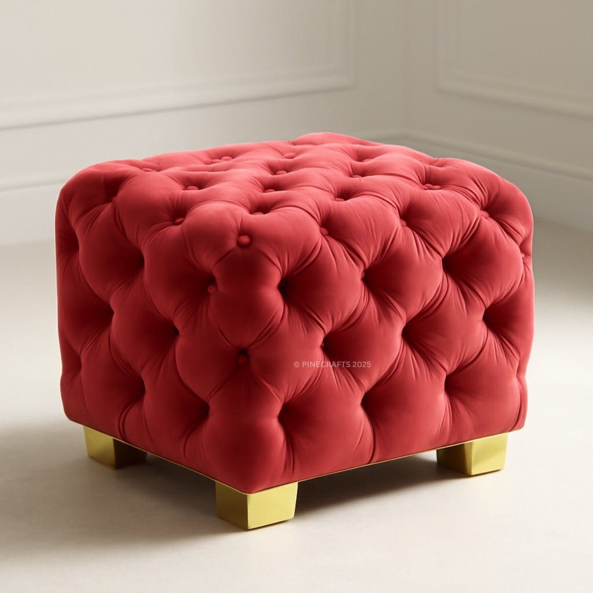 Red tufted ottoman with gold legs on a white background