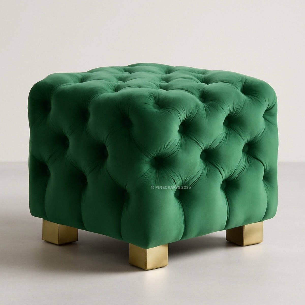 Green tufted ottoman with gold legs on a light background
