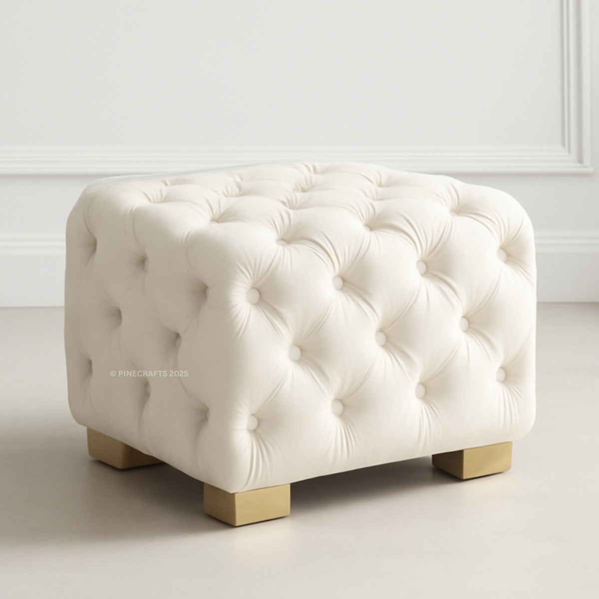 White tufted ottoman with gold legs on a light background
