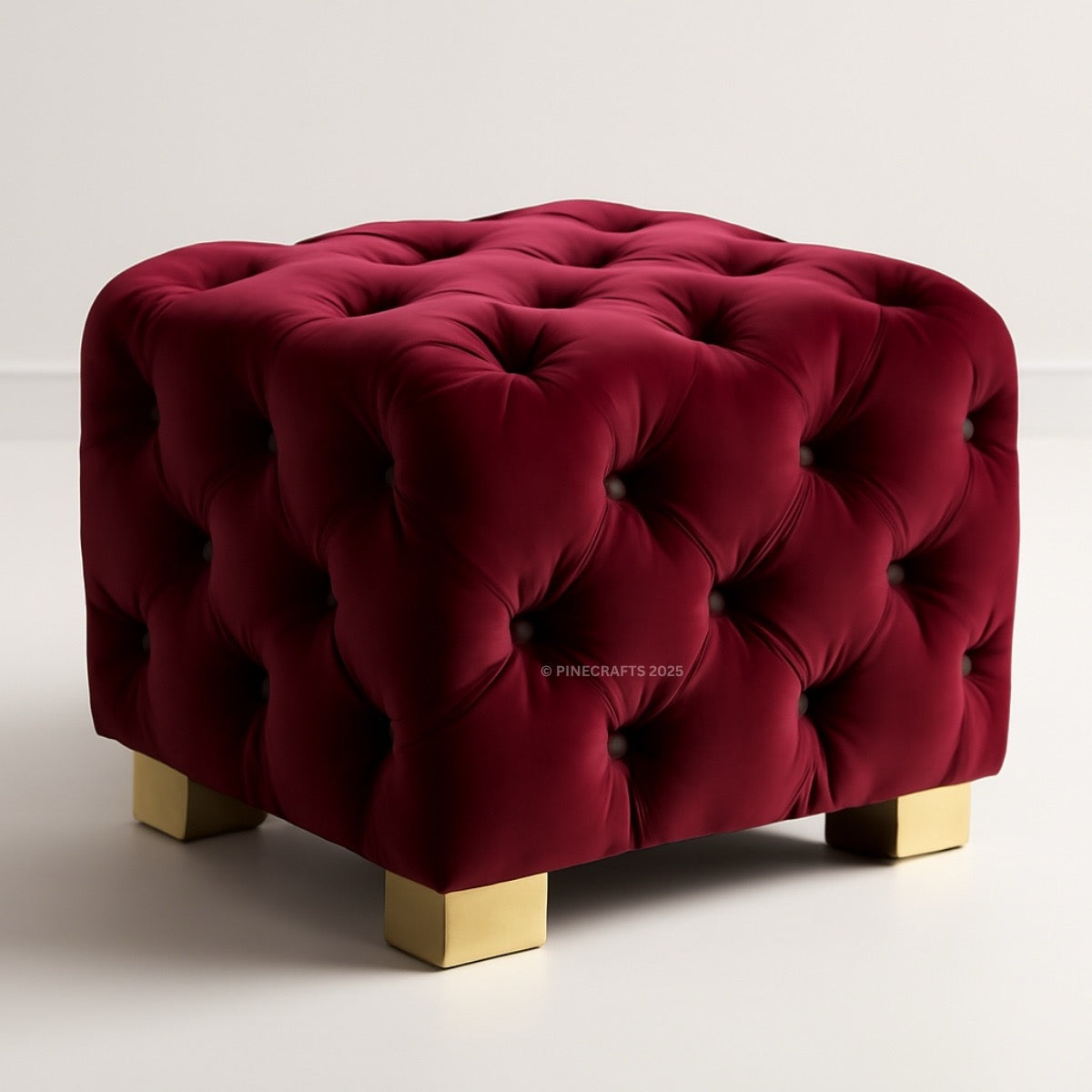 Red tufted ottoman with gold legs on a white background