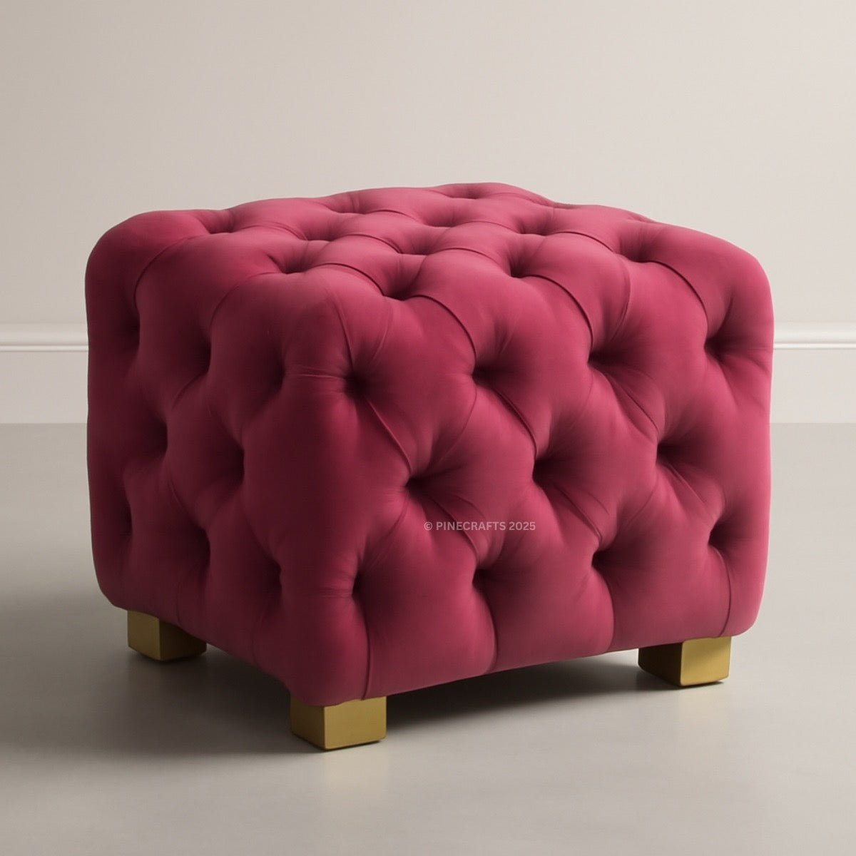 Pink tufted ottoman with gold legs on a neutral background