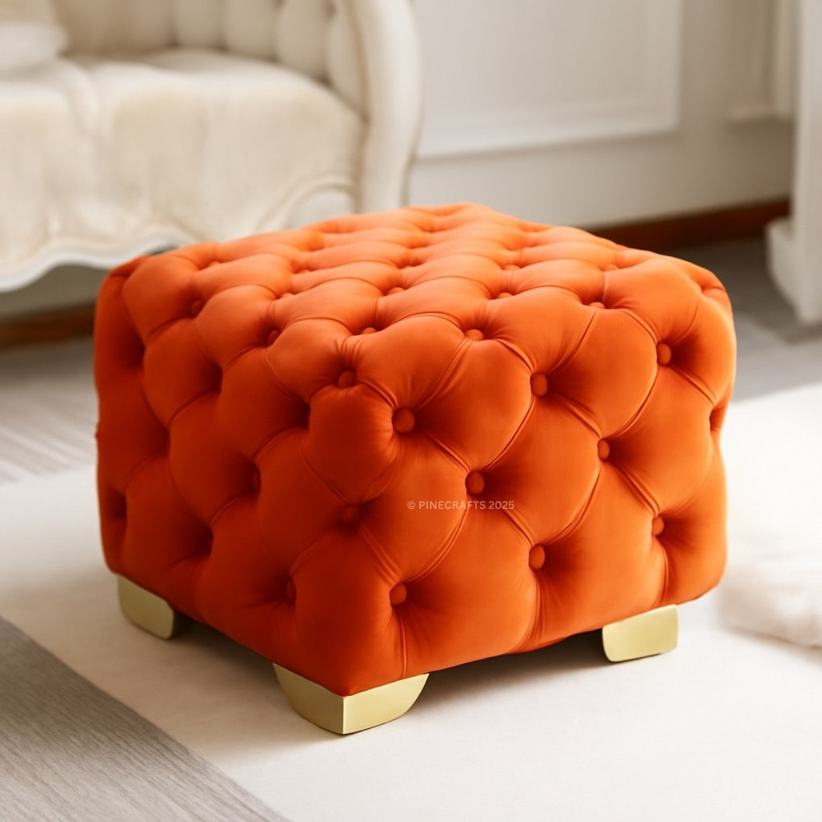 Orange tufted ottoman with gold legs in a living room setting