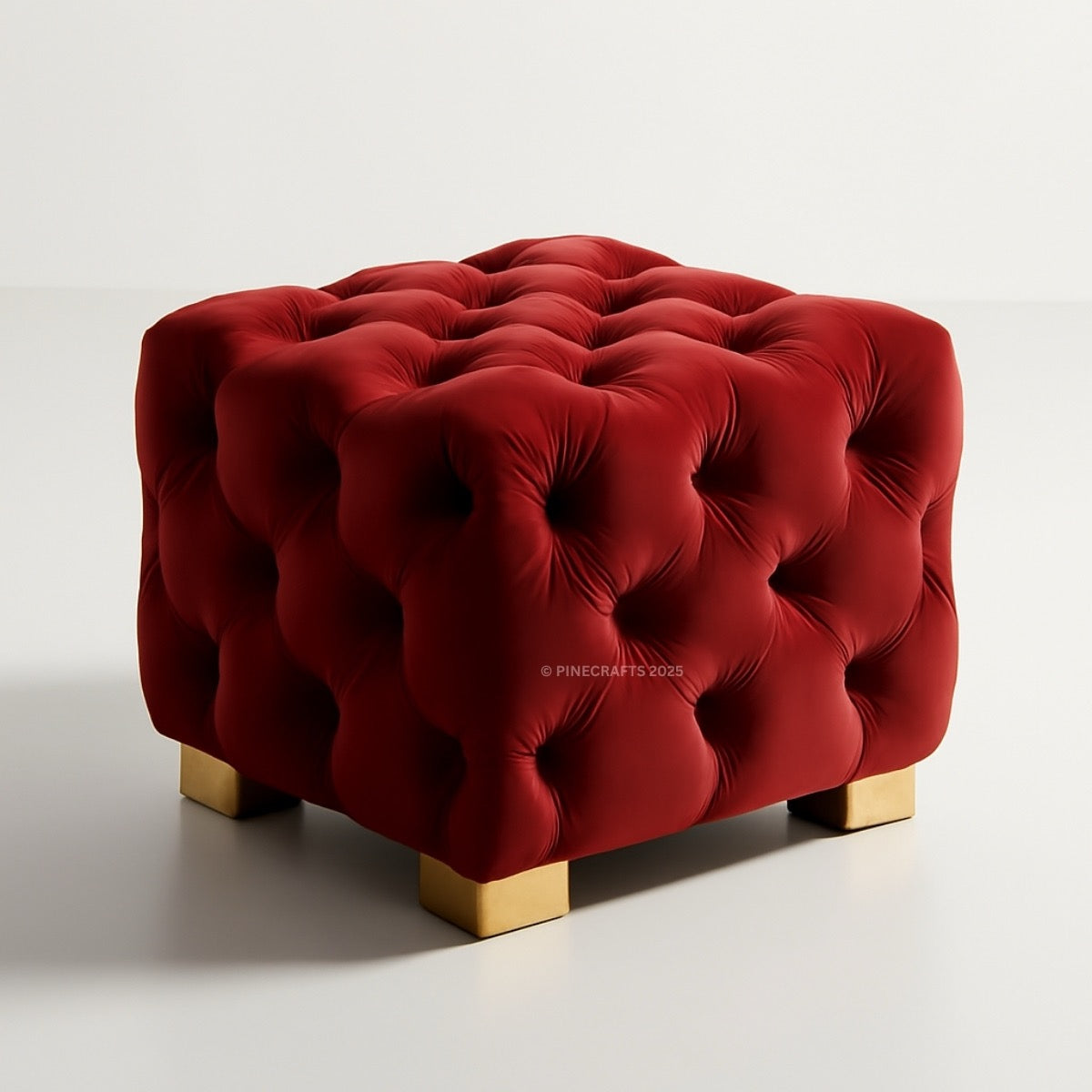 Red tufted ottoman with gold legs on a white background