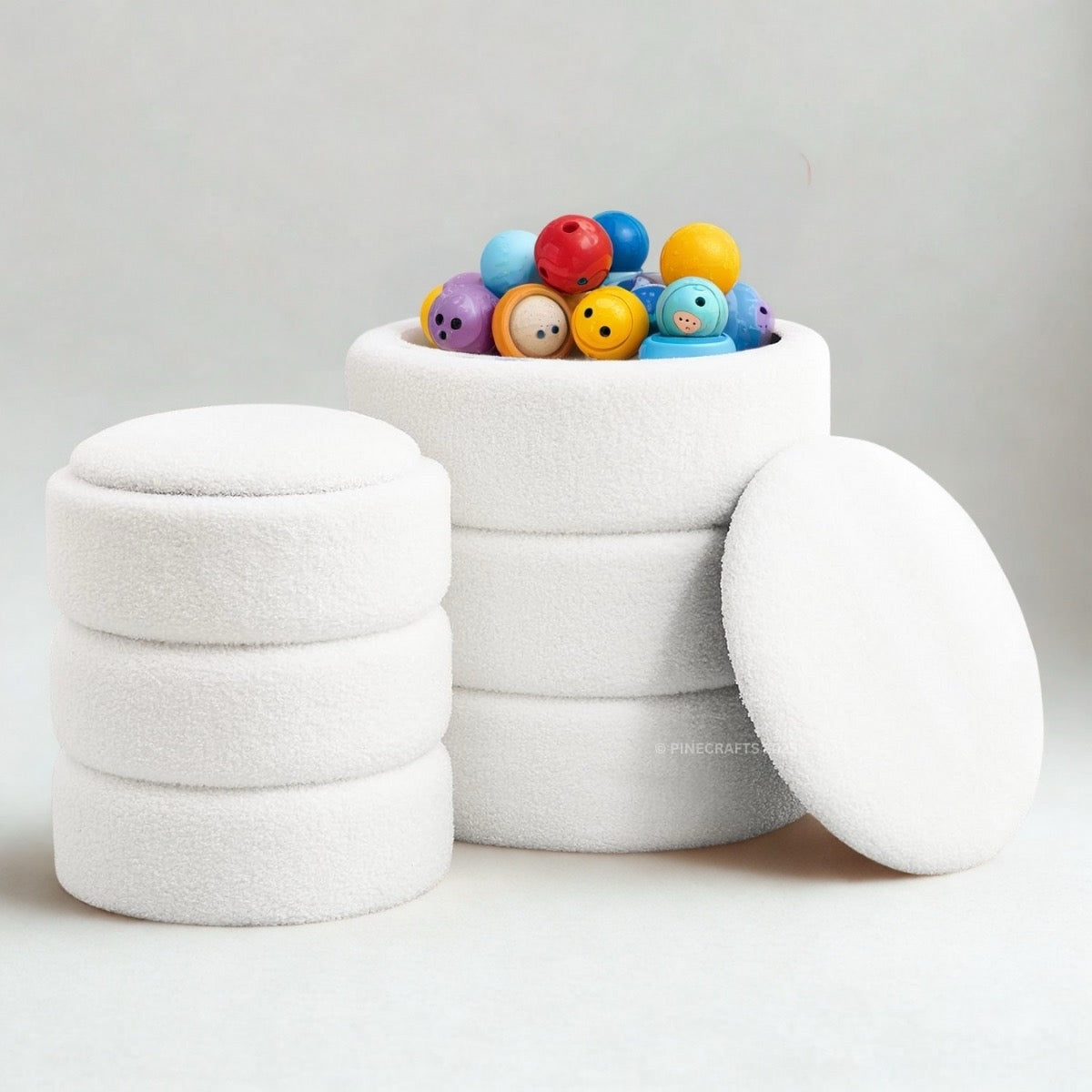 White textured container with colorful balls on a light gray background
