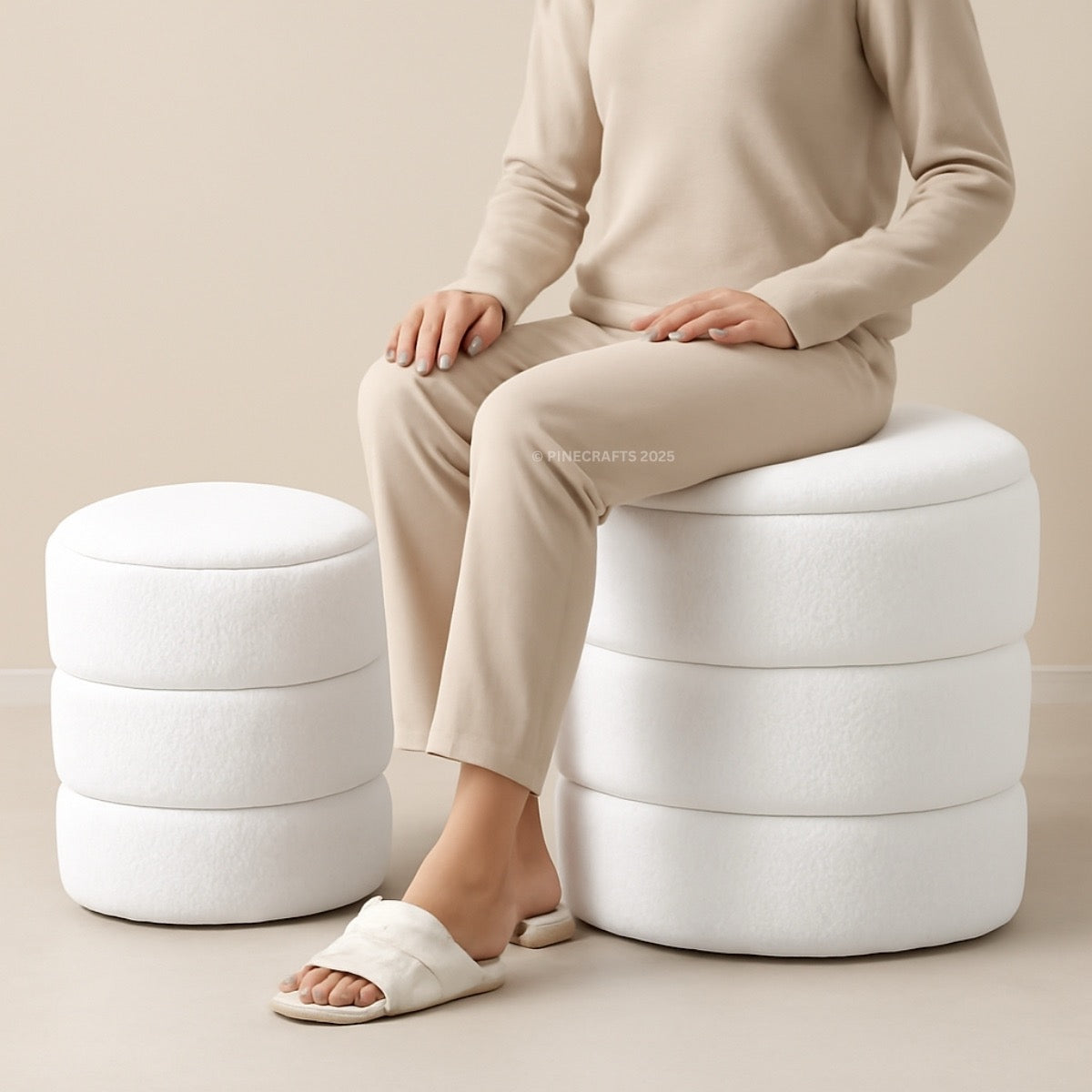 Person sitting on a white ottoman with a neutral background