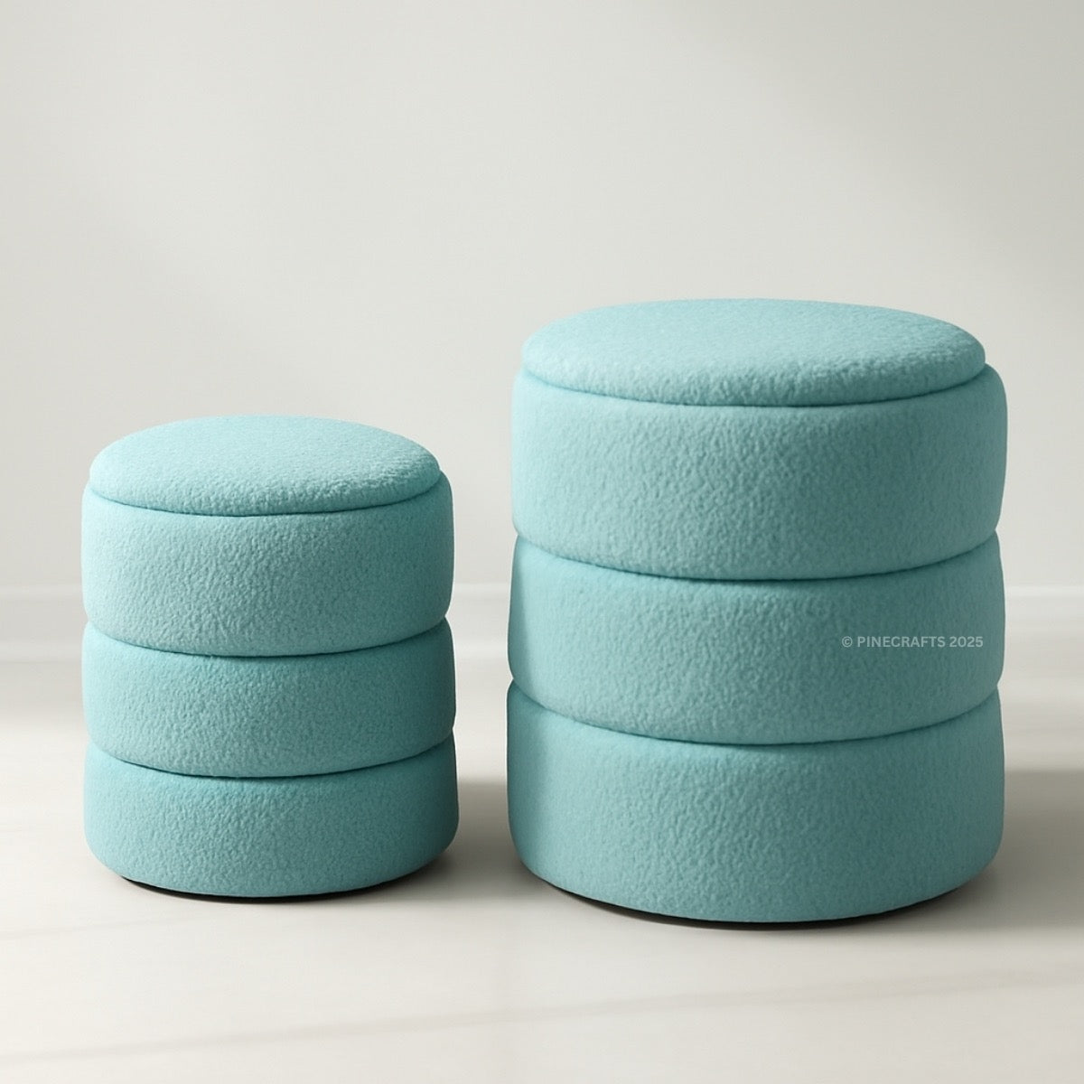 Two turquoise cylindrical ottomans stacked on a light gray background