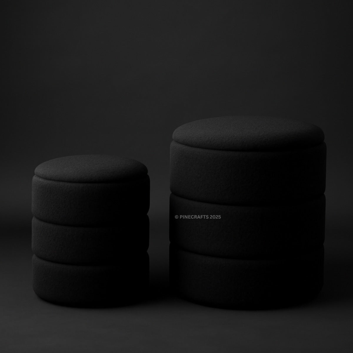 Two black cylindrical objects stacked on a dark background