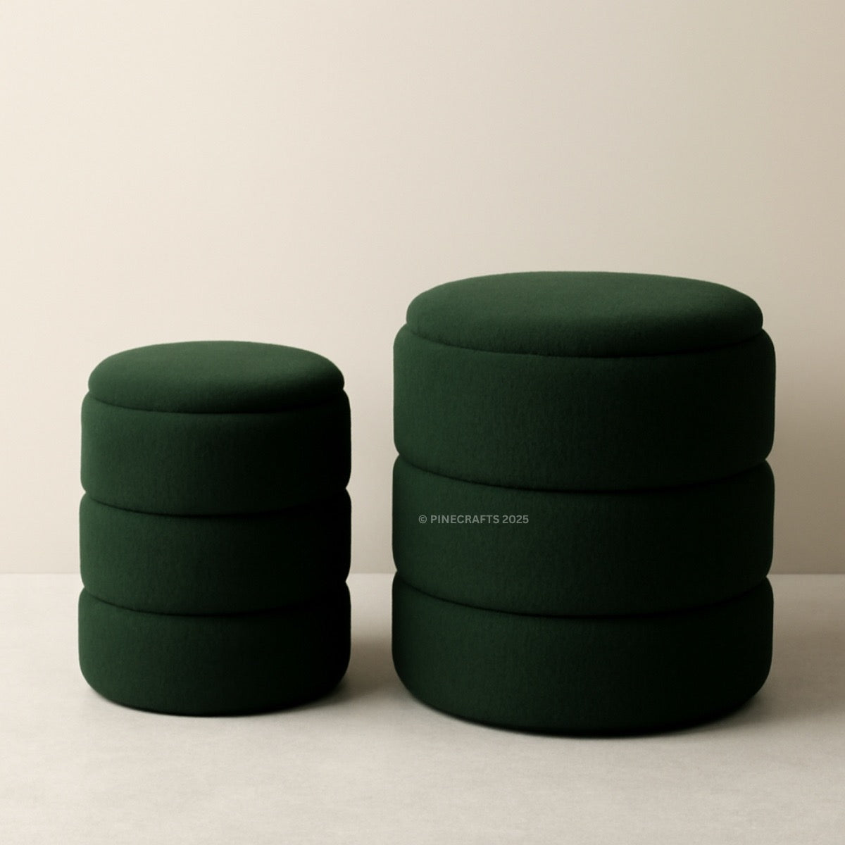 Two green cylindrical ottomans stacked on a beige background