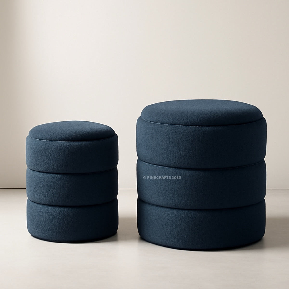 Two blue cylindrical ottomans stacked on a light background