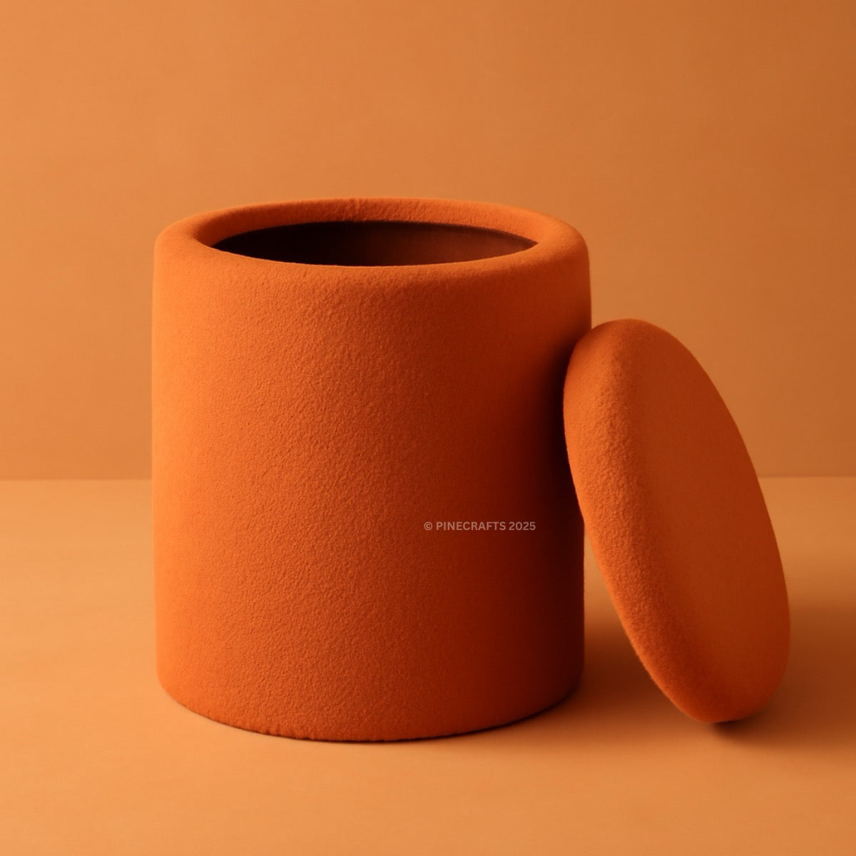 Orange textured container with lid on an orange background
