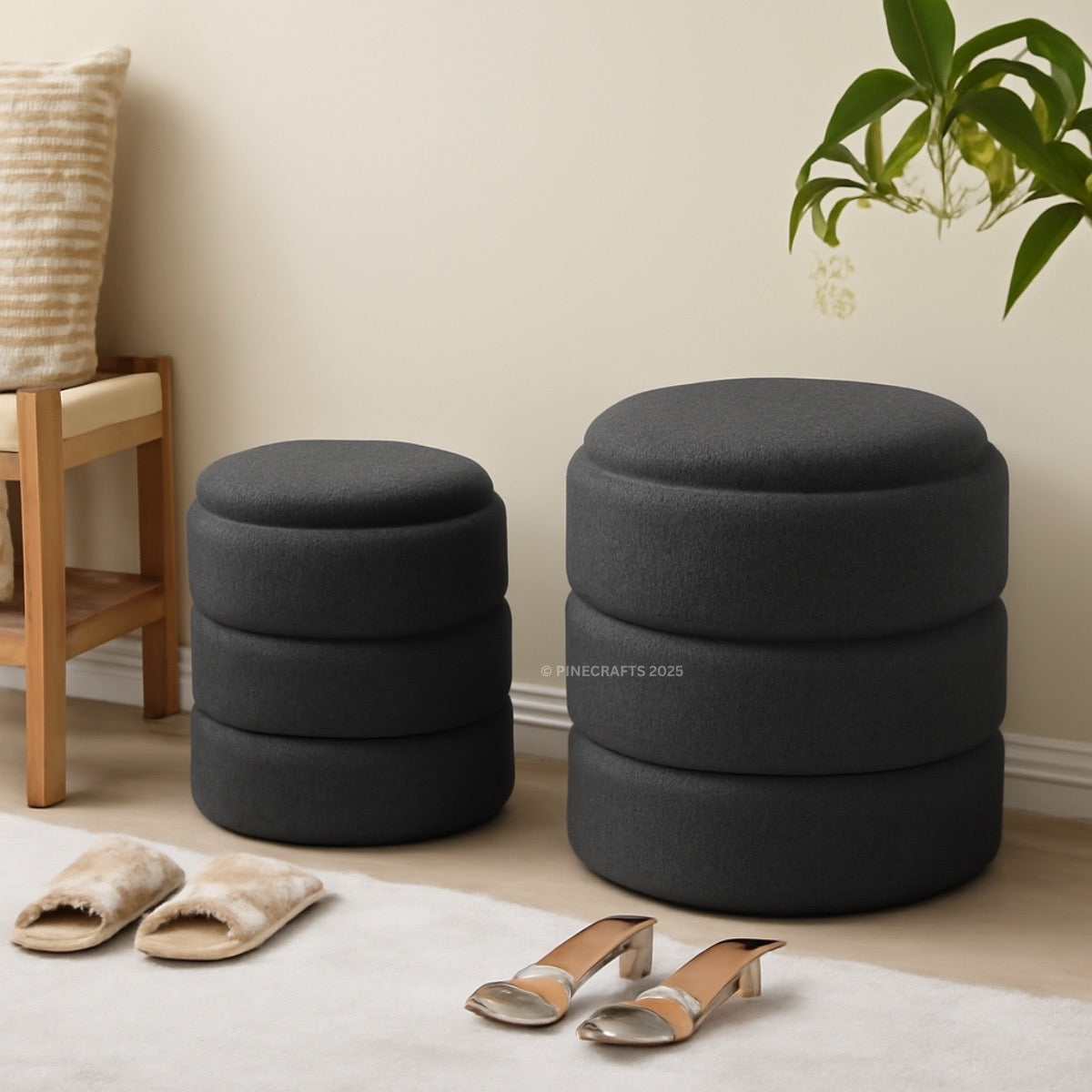 Two dark gray ottomans in a room with a chair, slippers, and high heels.
