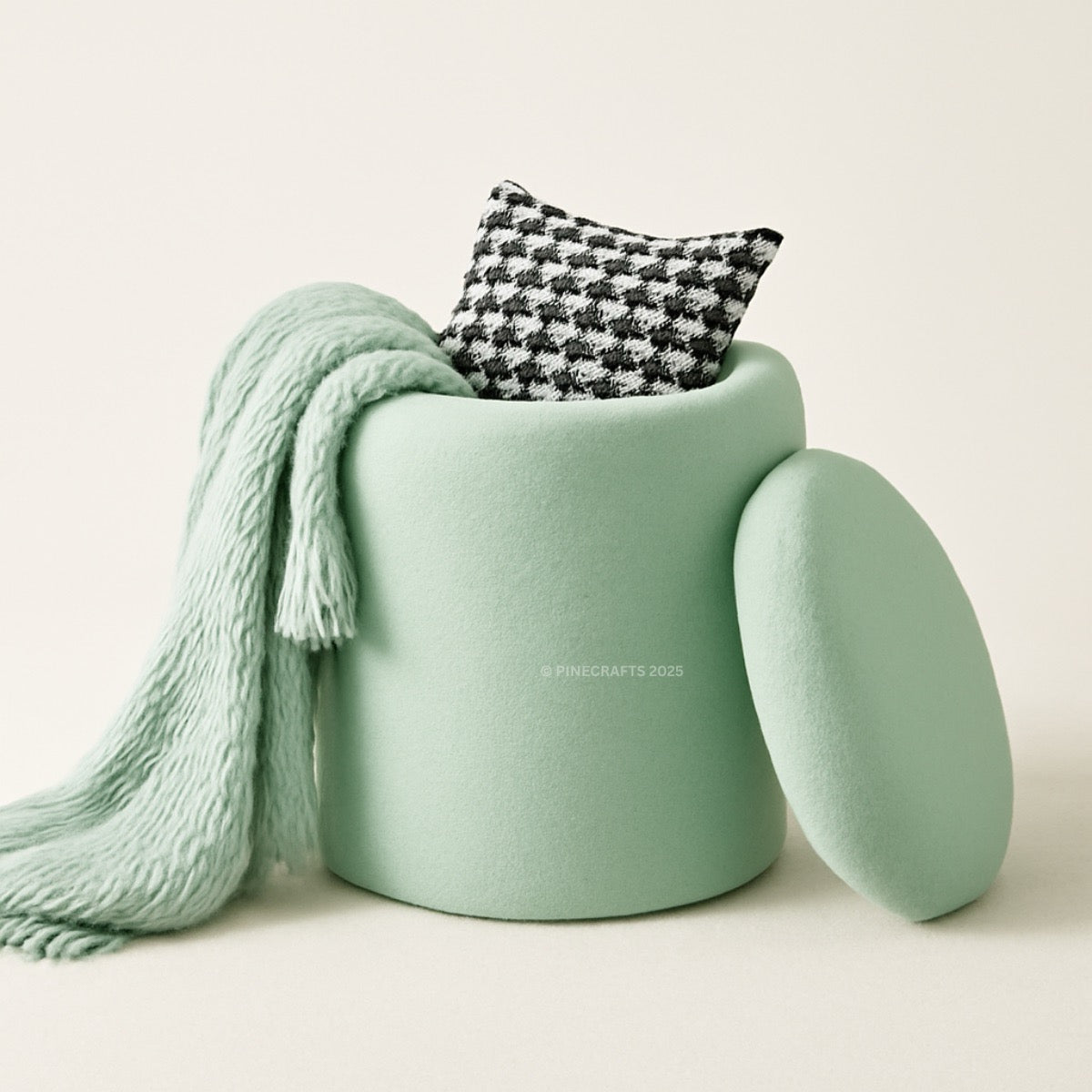 Light green cushion with a patterned pillow and knitted blanket on a neutral background