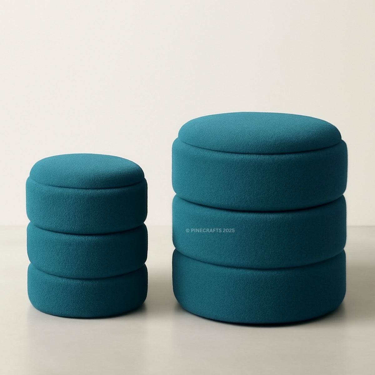 Two blue cylindrical ottomans stacked on a light background