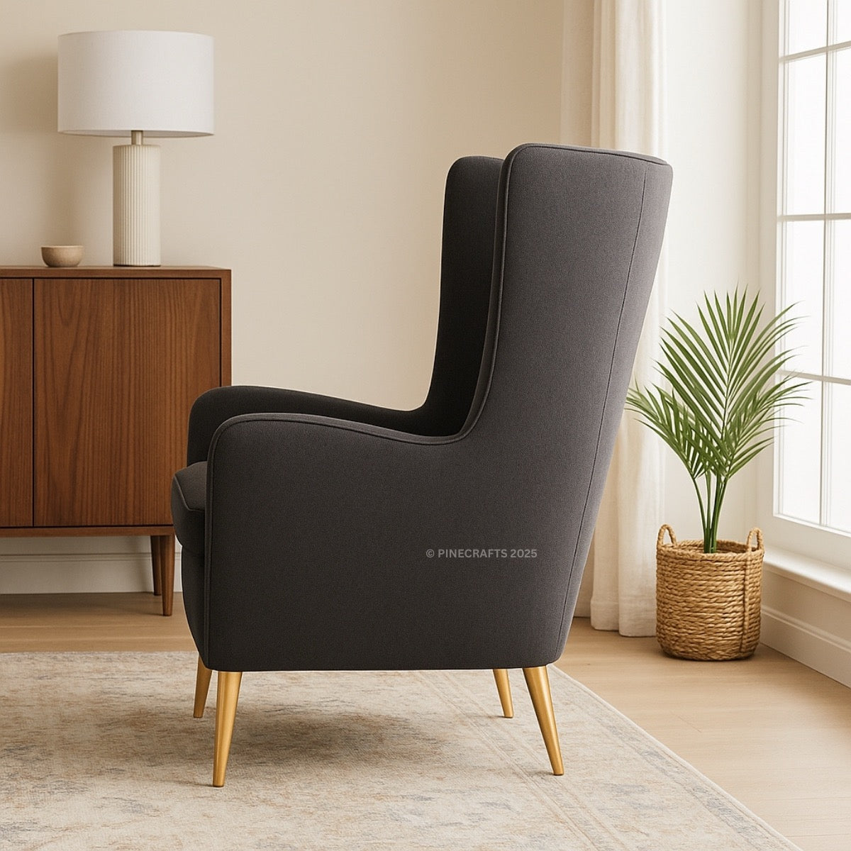 Gray armchair with gold legs in a room with a wooden cabinet and plant