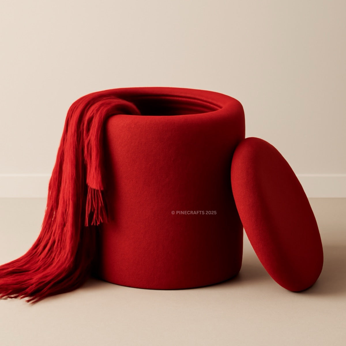 Red fabric ottoman with a matching red blanket draped over it on a beige background