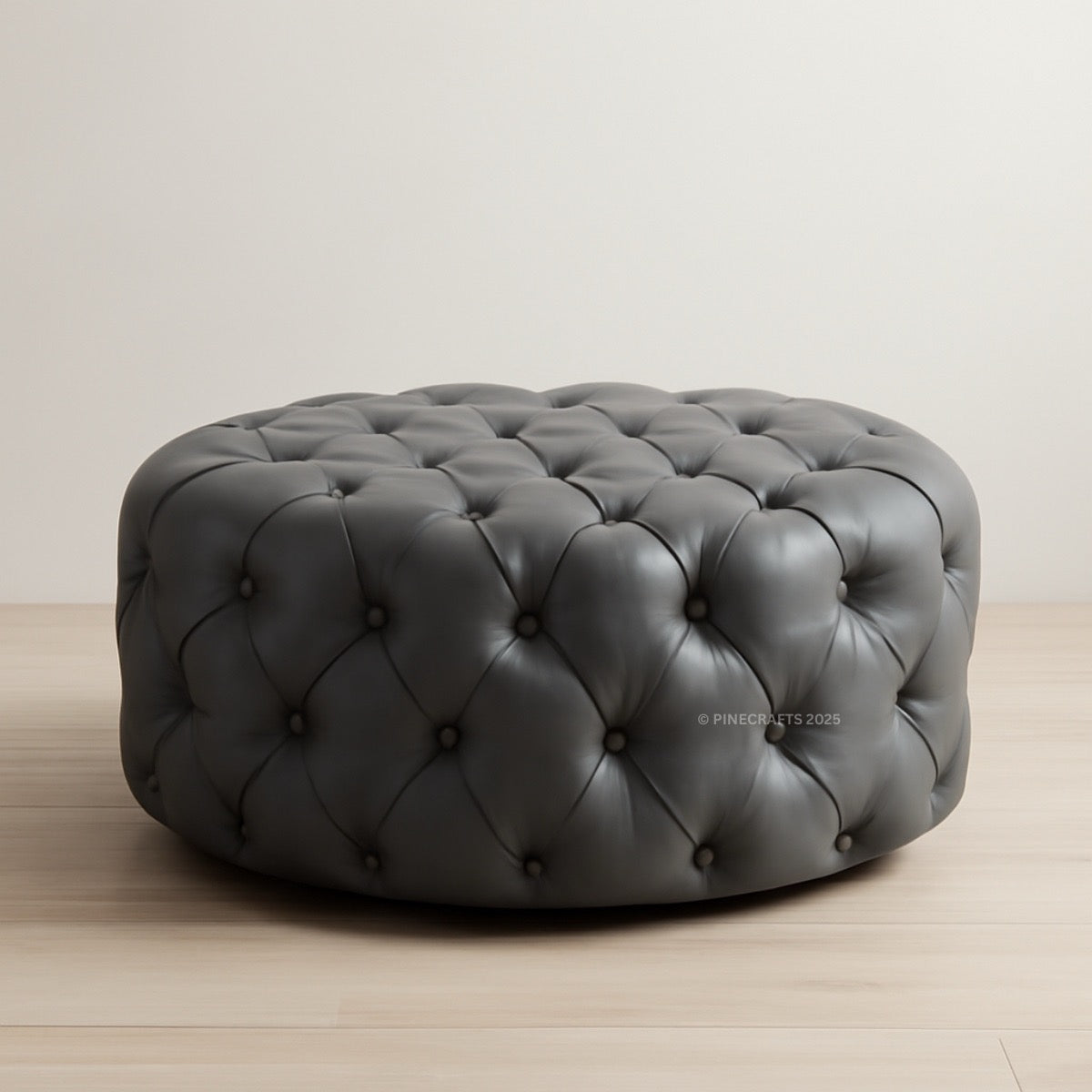 Gray tufted ottoman on a wooden floor with a plain background