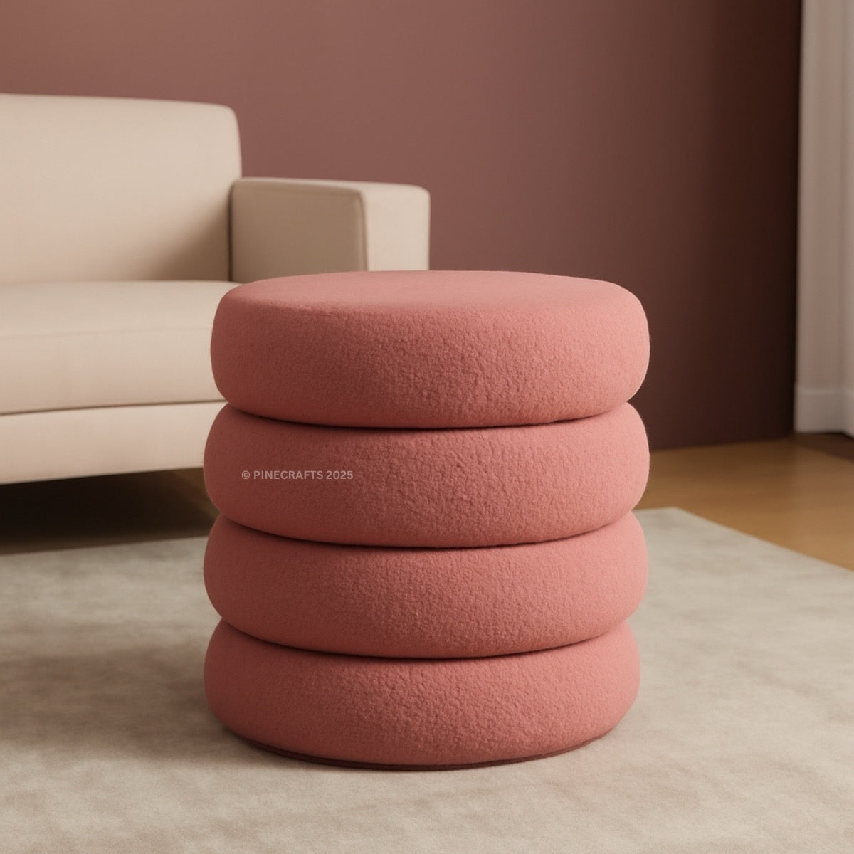 Stack of pink cushions on a beige rug with a beige sofa in the background