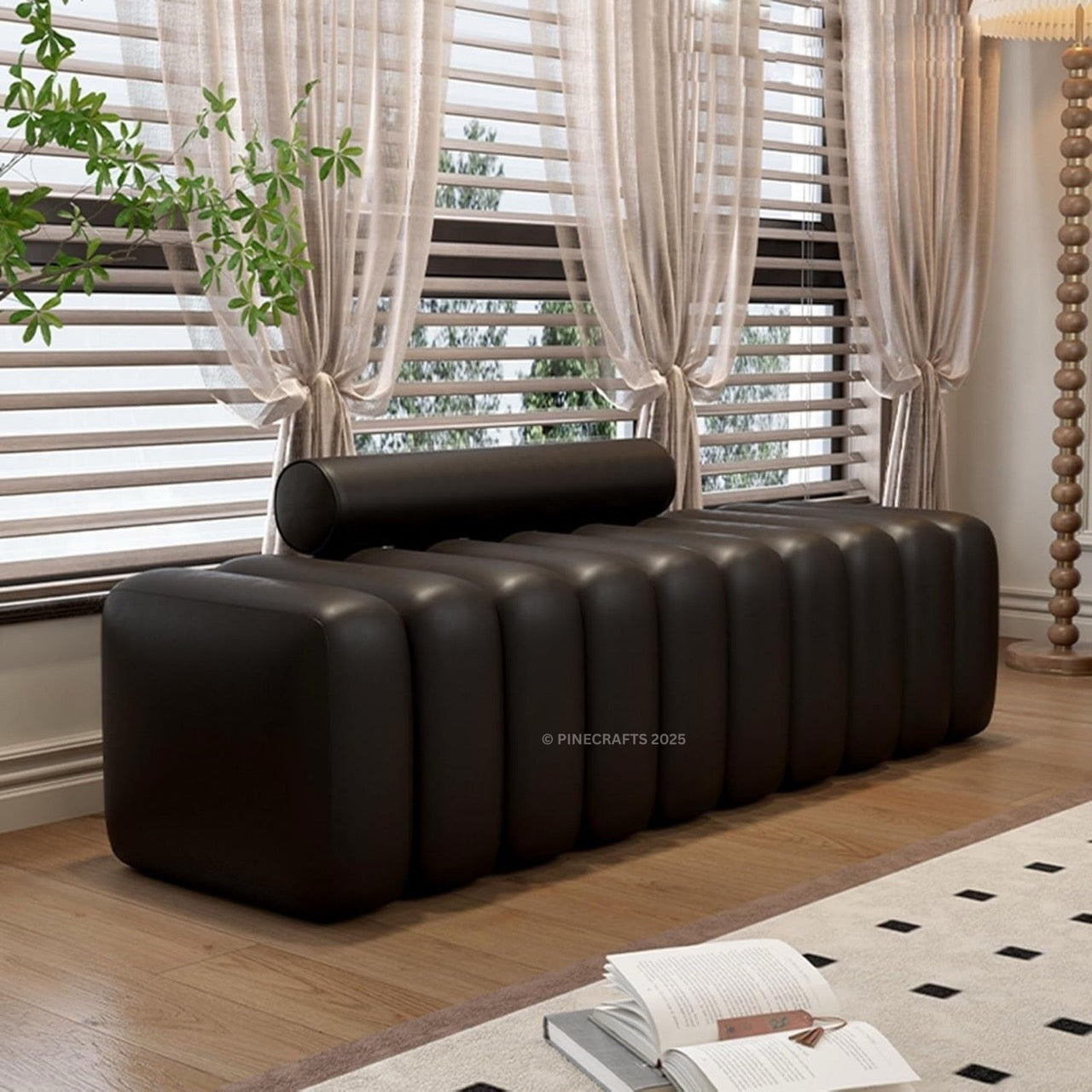 Modern black sofa in a room with large windows and curtains