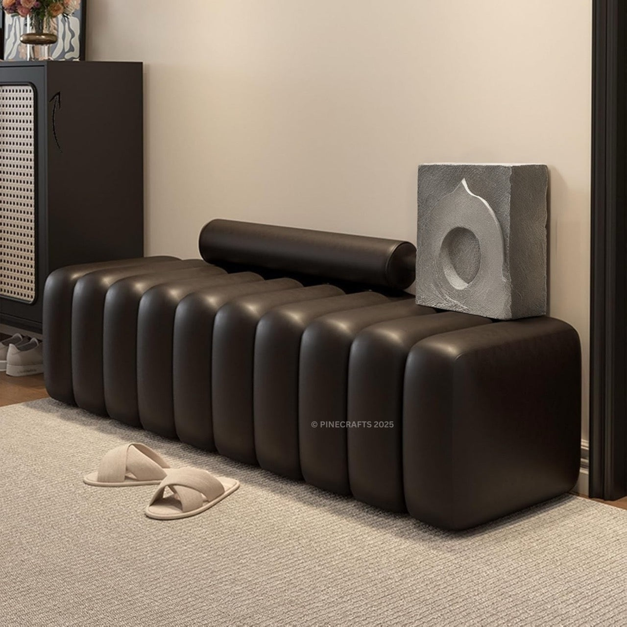 Modern black leather bench in a room with a textured wall and decorative elements.