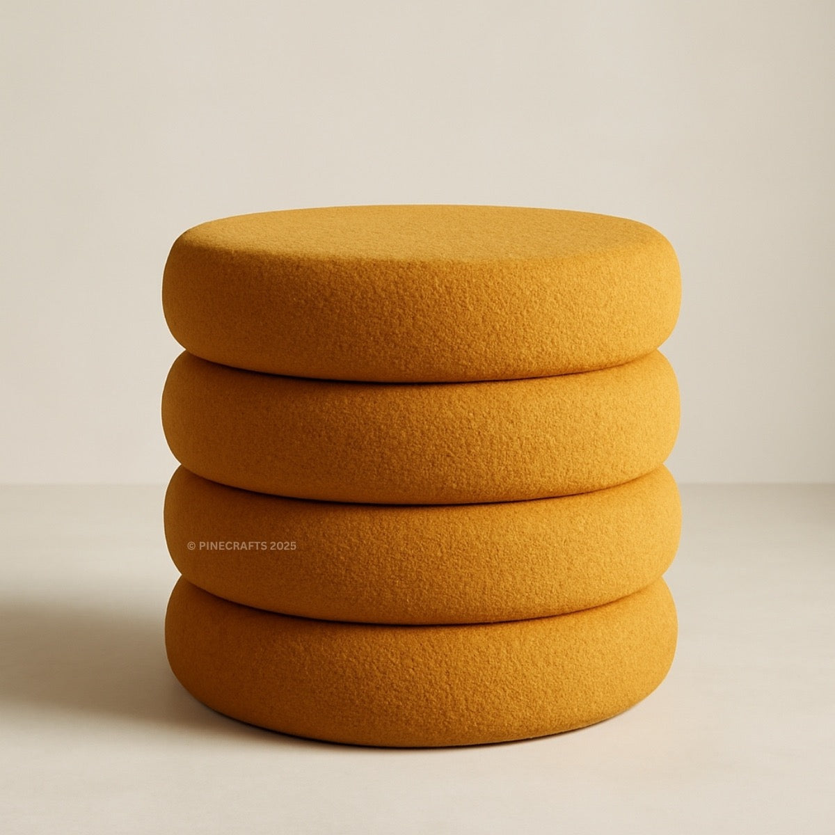 Stack of three mustard yellow cushions on a beige background