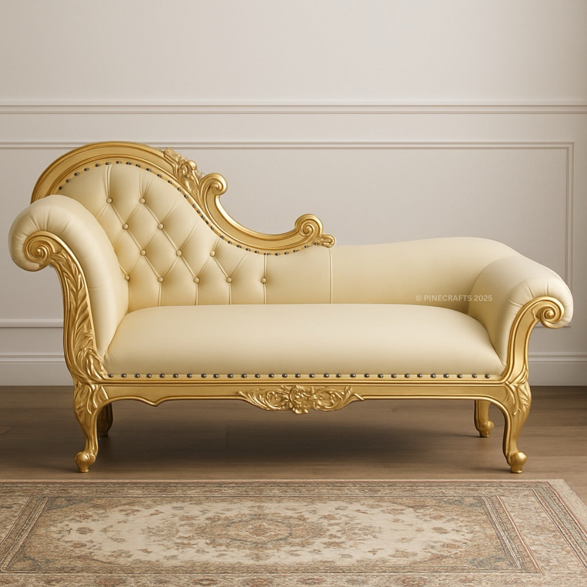 Decorative chaise lounge with gold frame and cream upholstery in a room with wooden floor and wall.