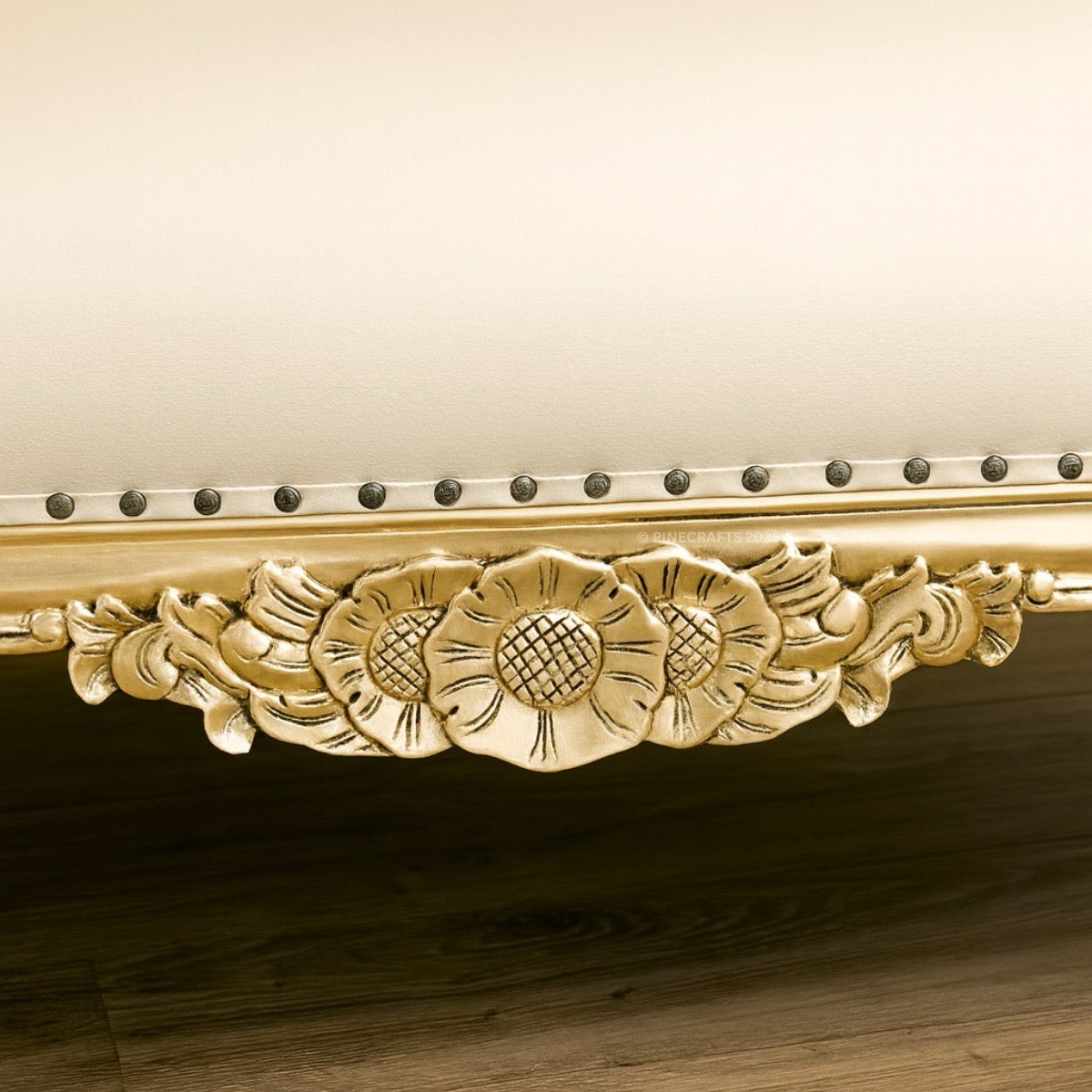 Decorative gold molding with floral patterns on a wooden surface