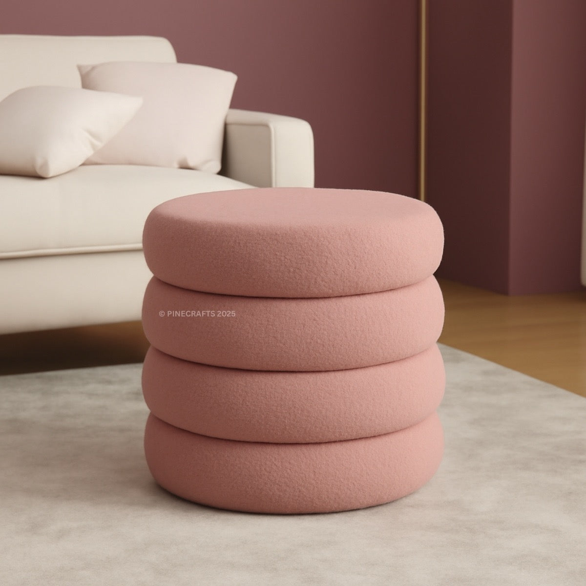 Stack of pink ottomans in a living room setting with a sofa and cushions.
