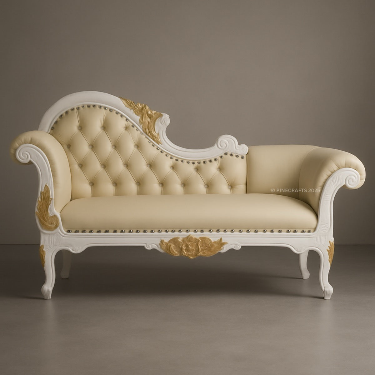 Decorative sofa with cream upholstery and gold accents on a plain background