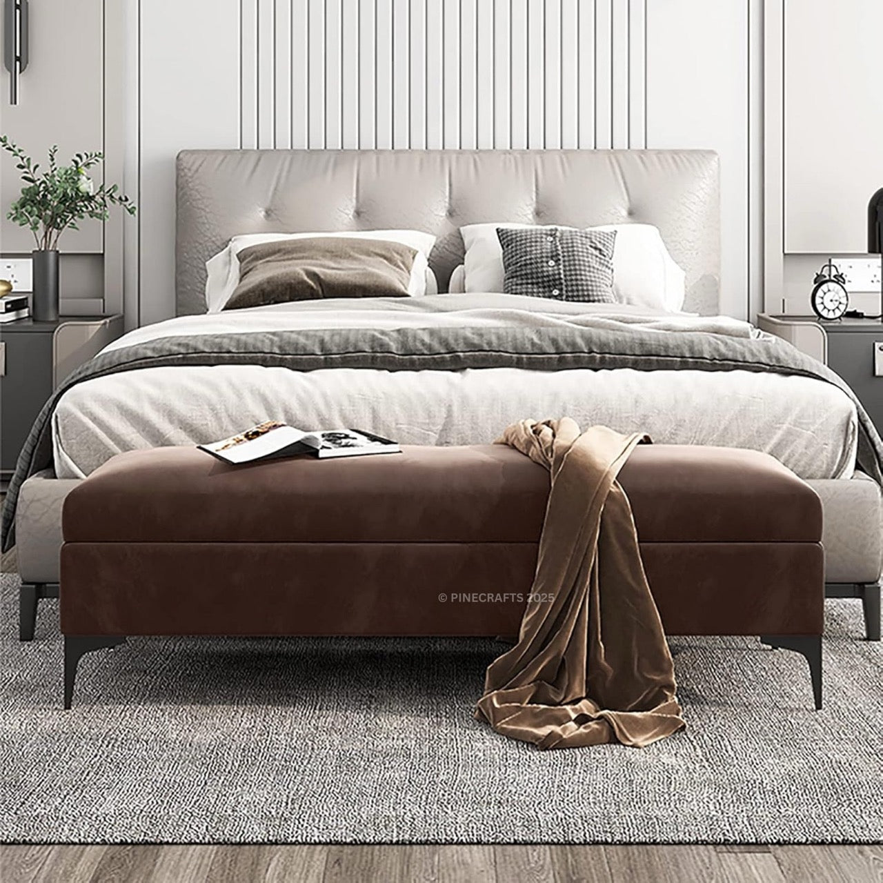 Modern bedroom with a bed and brown ottoman, featuring Pinecrafts branding.