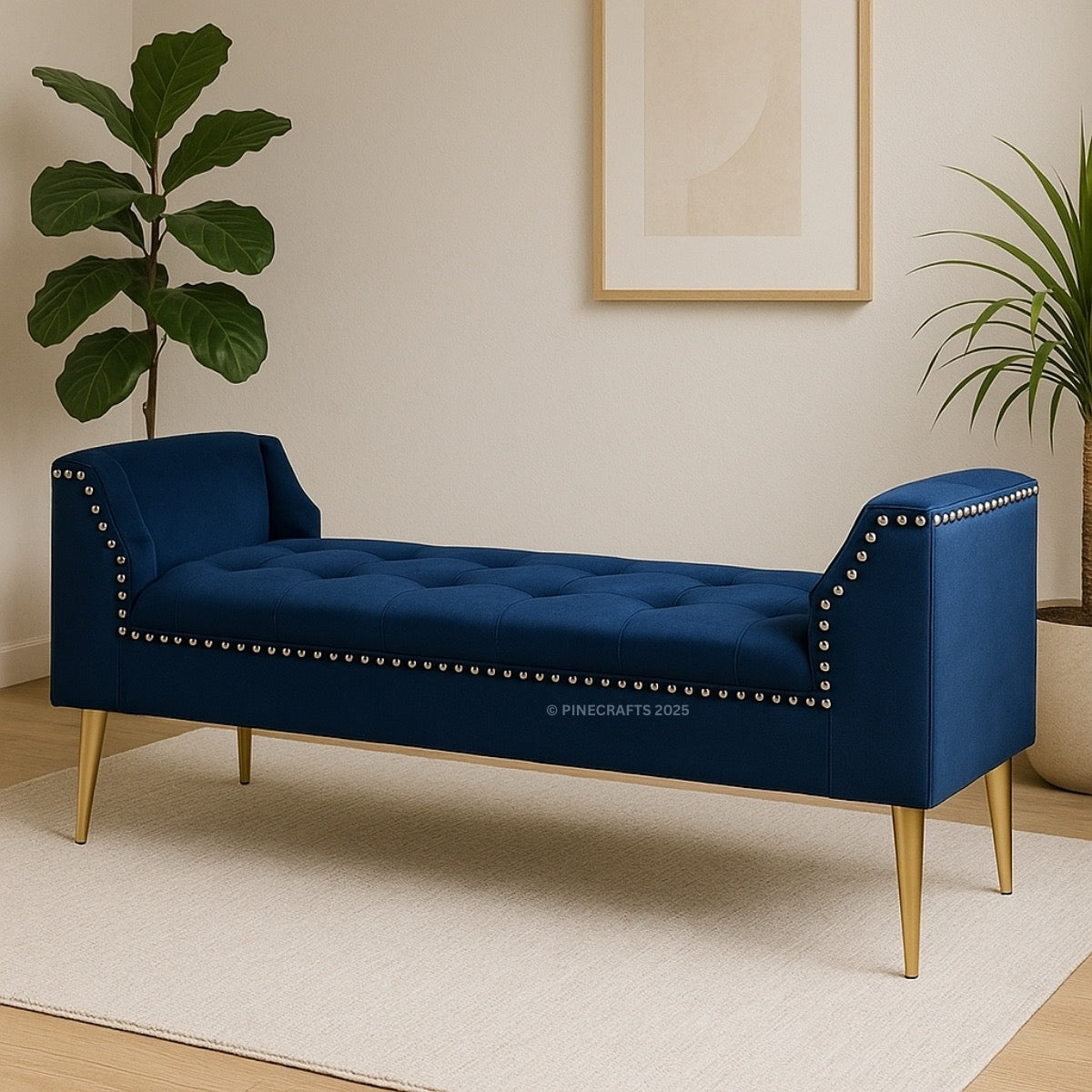 Blue tufted bench with gold legs in a room with plants and a framed picture.