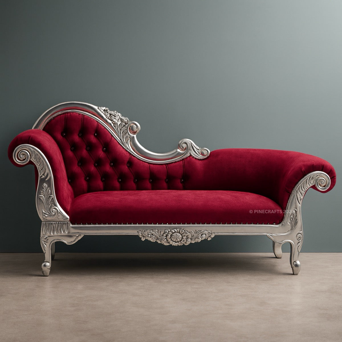 Red velvet chaise lounge with silver decorative elements on a gray background