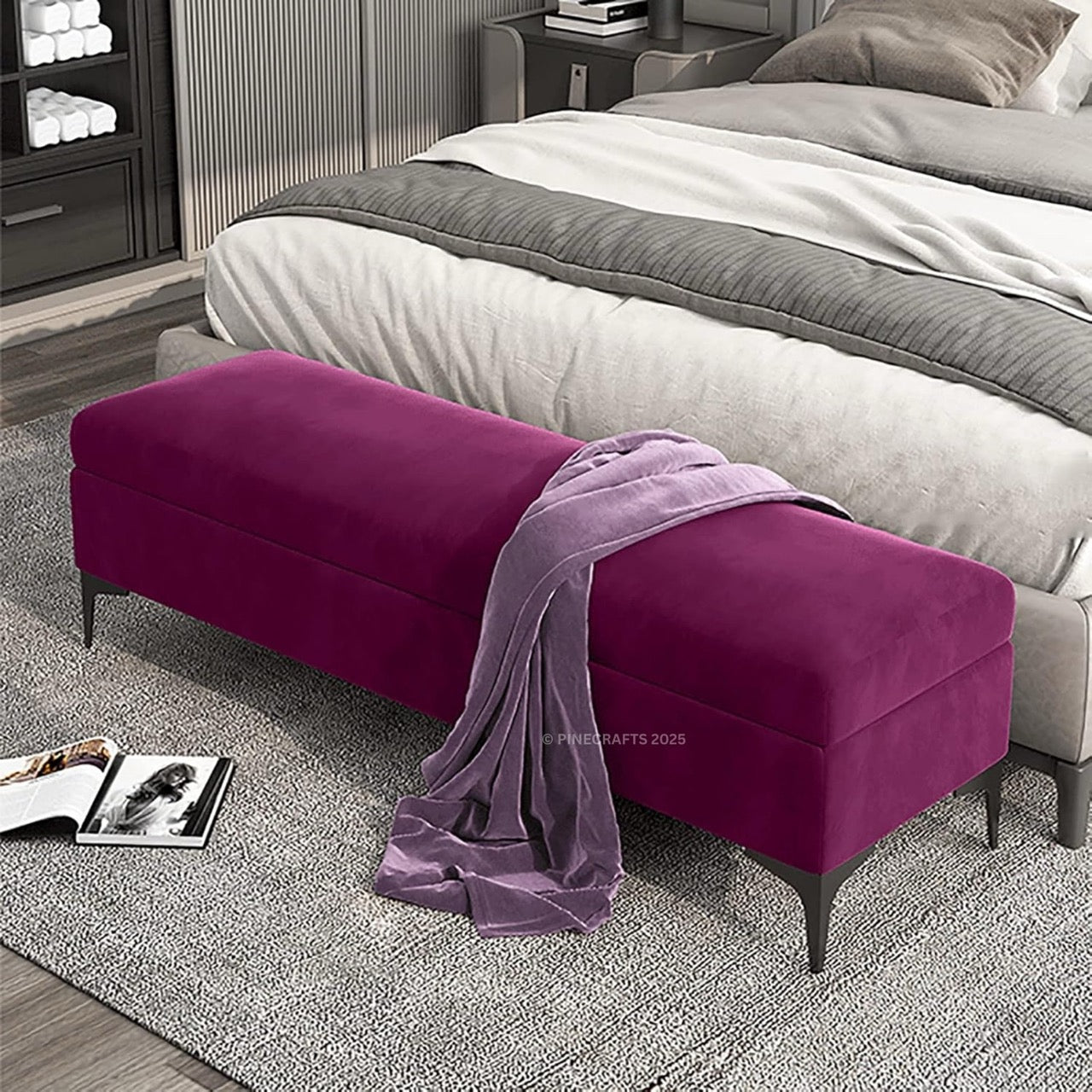 Purple ottoman with a blanket on top in a bedroom setting