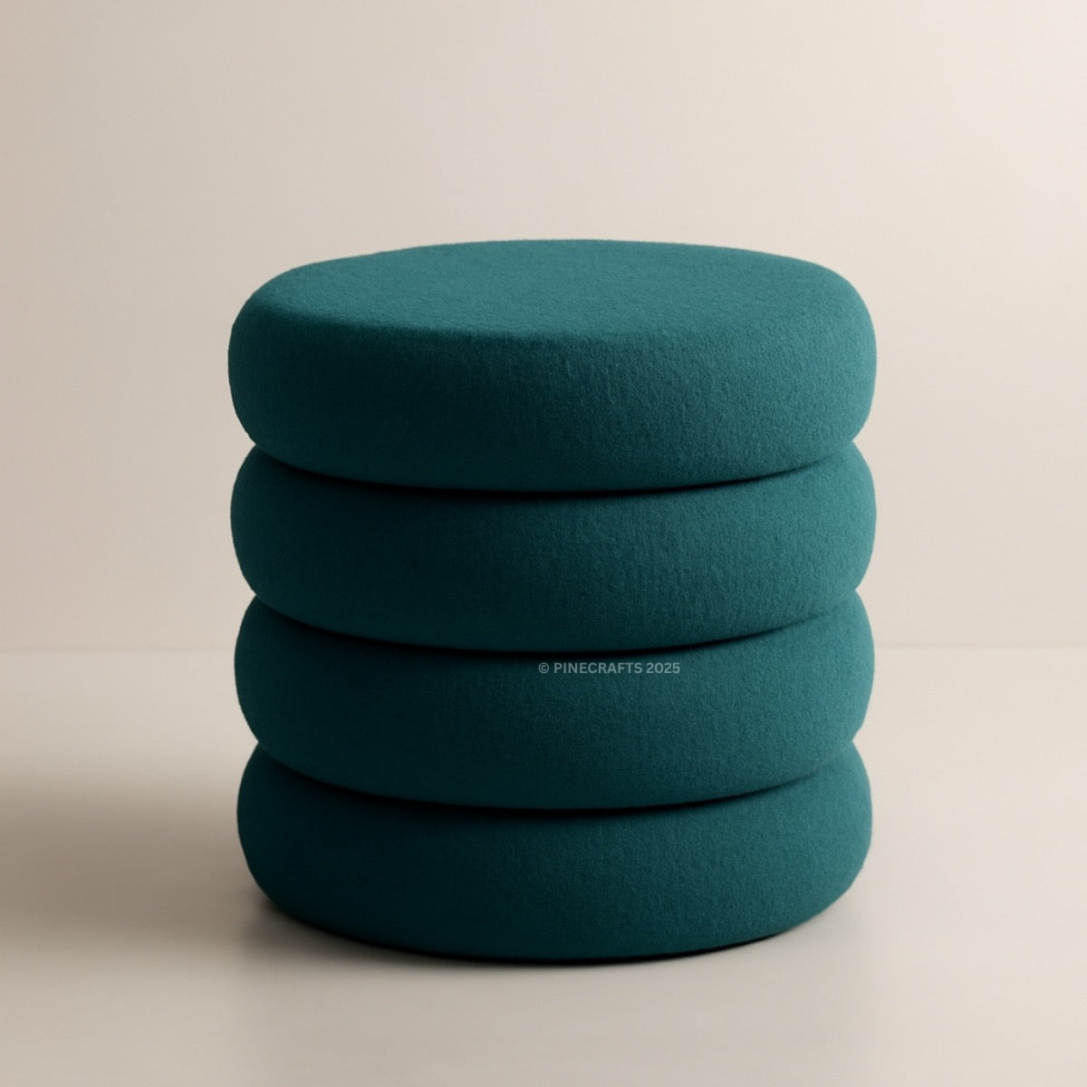 Stack of teal cushions on a beige background