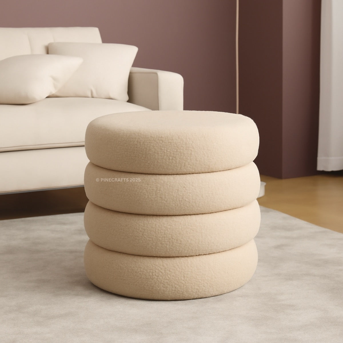 Beige ottoman with stacked circular designs in a living room setting.